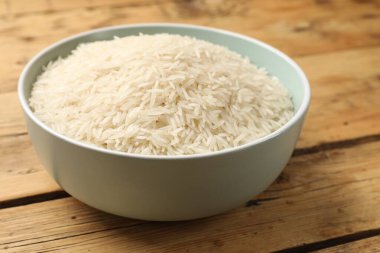 Tabakta çiğ basmati pilavı, ahşap masada, yakın plan.