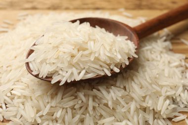 Çiğ basmati pilavı ve ahşap kaşık, yakın plan.