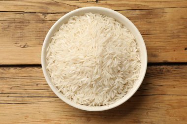 Tabakta çiğ basmati pilavı, ahşap masa, üst manzara.