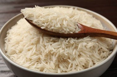Çiğ basmati pilavı ve ahşap kaşık masada, yakın plan.