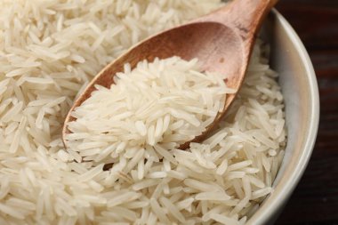 Çiğ basmati pilavı ve ahşap kaşık masada, yakın plan.