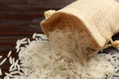 Çiğ basmati pilavı ve çanta ahşap masada, yakın plan.