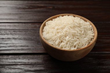Tahta masadaki kase içinde çiğ basmati pilavı, metin için yer.