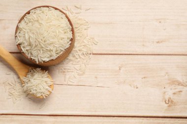 Beyaz ahşap masa üzerinde çiğ basmati pilavı. Metin için boşluk
