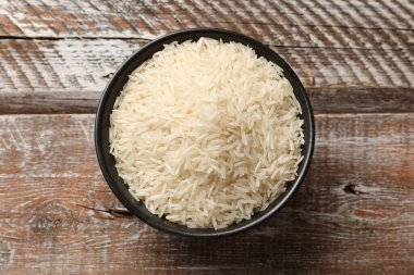 Tabakta çiğ basmati pilavı, ahşap masa, üst manzara.