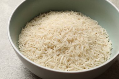 Tabakta çiğ basmati pilavı, gri masada, yakın plan.