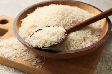 Tabakta çiğ basmati pilavı, masada kaşık, yakın plan.