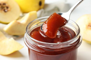 Masada kavanozdan lezzetli ev yapımı ayva reçeli alıyorum. Yakın plan.