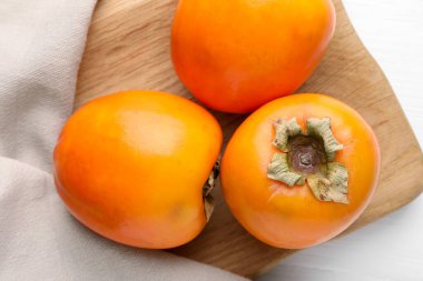 Beyaz ahşap masa üzerinde leziz olgun hurma ağaçları olan bir pano.