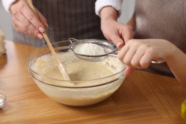 Ekmek yapıyorum. Anne ve kızı mutfaktaki ahşap masada hamuru hazırlıyorlar.