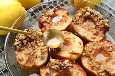 Lezzetli balı, fırında pişmiş ayva kasesine döküyorum. Masadaki, yakından.