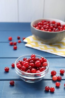 Fresh ripe cranberries on blue wooden table