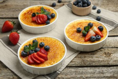 Böğürtlenli ve nane şekerli nefis creme brulee ahşap masada, yakın plan