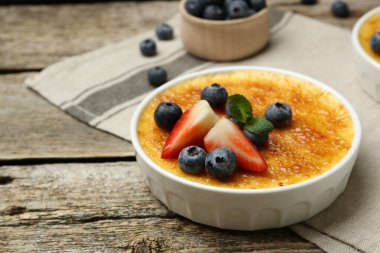 Böğürtlenli nefis creme brulee ve ahşap masada nane şekeri, yakın plan. Metin için boşluk