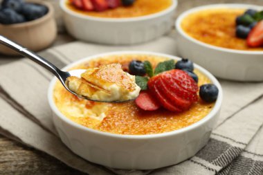 Böğürtlenli ve nane şekerli nefis creme brulee 'yi ahşap masadan alıp, yakın plan