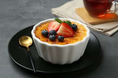 Böğürtlenli nefis creme brulee ve gri masadaki nane şekeri, yakın plan