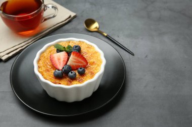 Böğürtlenli nefis creme brulee ve gri masadaki nane şekeri. Metin için boşluk