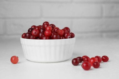 Beyaz masada olgun kızılcıklar kasede