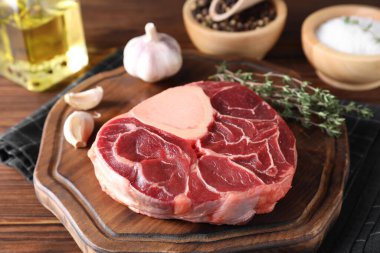 Tahta masada çiğ et, sarımsak ve kekik, yakın plan.