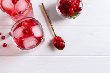 Lezzetli yaban mersini suyu bardakta buz ve beyaz ahşap masada taze böğürtlen, düz yatak. Metin için boşluk