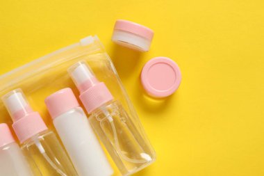 Sarı zemin üzerinde kozmetik seyahat seti olan plastik torba, düz. Metin için boşluk