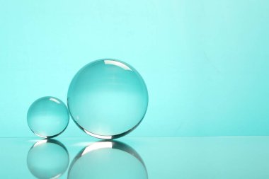 Aynanın yüzeyindeki şeffaf cam küreler turkuaz arka planda. Metin için boşluk