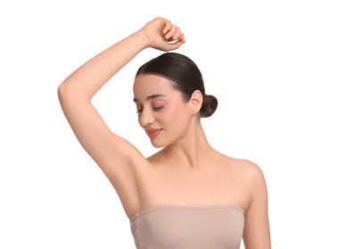 Güzel bir kadın, beyaz arka planda pürüzsüz, temiz bir ciltle koltukaltı gösteriyor.