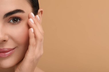 Bej arka planda sağlıklı cildi olan güzel bir kadın, yakın plan. Metin için boşluk