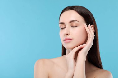 Açık mavi arka planda güzel bir genç kadının portresi. Metin için boşluk