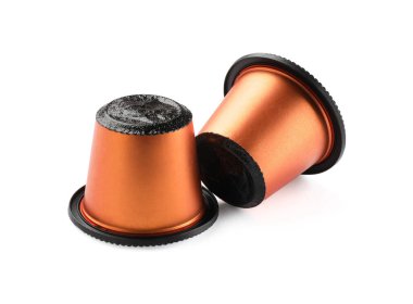 Beyaz üzerine izole edilmiş iki plastik kahve kapsülü.