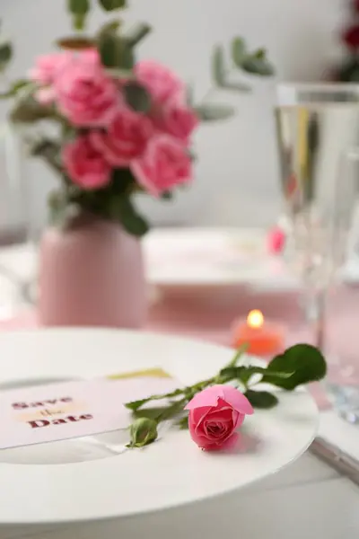 Romantic table setting. Plate with pink rose on table, closeup