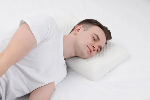 Man sleeping on orthopedic pillow in bed
