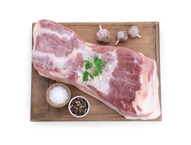 Çiğ domuz göbeği, maydanoz, sarımsak ve baharatlar beyaza izole edilmiş.