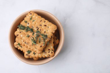 Mısır gevreği krakerleri, keten, susam tohumu ve kekik kasede beyaz mermer masa, üst manzara. Metin için boşluk