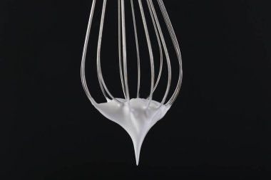 Siyah arka planda krem şantili çırpma çırpma, yakın plan