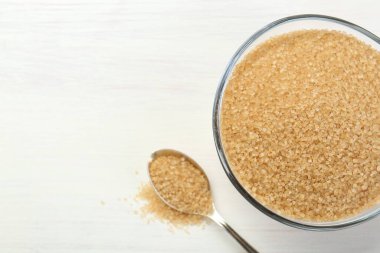 Kahverengi şeker kasede ve kaşık beyaz tahta masada, düz yerde. Metin için boşluk