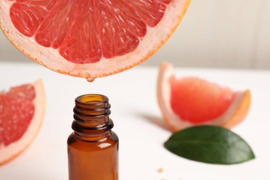 Masada meyve suyundan şişeye greyfurt suyu damlatıyor, yakın plan. Metin için boşluk