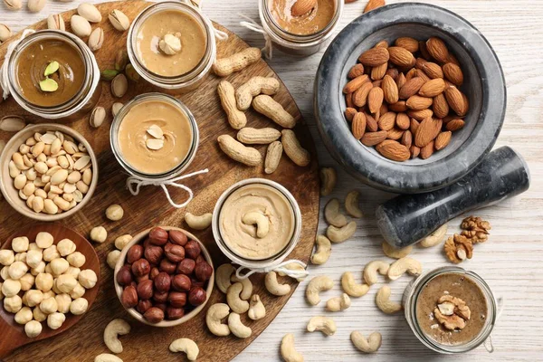 Farklı fıstıklardan fındık ezmesi yapıyorum. Düz kompozisyon ahşap masanın üzerinde.