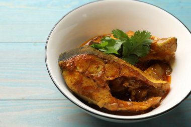 Açık mavi ahşap masadaki lezzetli balık körisi, yakın plan. Hint mutfağı