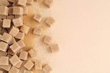 Esmer şeker küpleri bej arka planda, üst manzara. Metin için boşluk