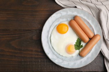 Lezzetli haşlanmış sosisler, sahanın üstünde kızarmış yumurta ve maydanoz. Metin için boşluk