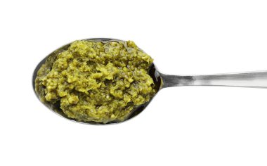 Beyaz üzerine izole edilmiş lezzetli pesto soslu kaşık.