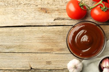Düz kompozisyon ve lezzetli barbekü sosu ahşap masada duruyordu. Metin için boşluk
