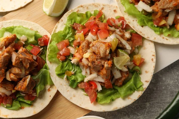 Sebzeli lezzetli tacolar ve gri desenli masa üzerinde et.