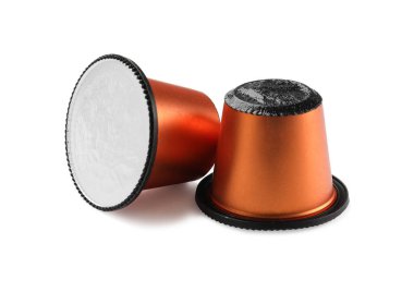 Beyaz üzerine izole edilmiş iki plastik kahve kapsülü.