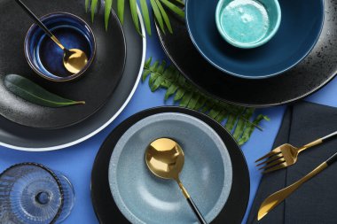 Mavi zemin üzerinde şık seramik plakalar ve çiçek dekoru ile düz konum