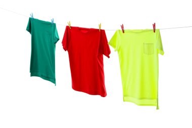 Çamaşır ipinde kurumuş renkli tişörtler beyazda izole edilmiş.