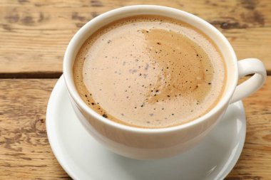 Ahşap masada bir fincan aromatik kahve, yakın plan.