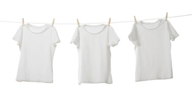 Çamaşır ipinde kuruyan birçok tişört beyaza izole edilmiş.