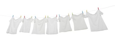 Çamaşır ipinde kuruyan birçok tişört beyaza izole edilmiş.